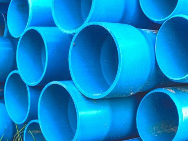 Su ulaştırma araçları için mavi plastik borular demetleri. Boru toplu inşaat alanında.