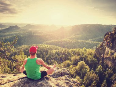 Meditasyon yoga pozisyon üst kısmında bir dağlar. Adam meditasyon dağ Güneş doğarken