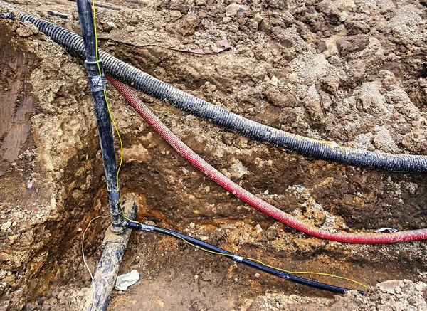 通信ネットワーク接続の金属と繊維の光ケーブルのラインの建物 トレンチを運ぶガス水道電気下水および携帯電話サービスのための導管 — ストック写真