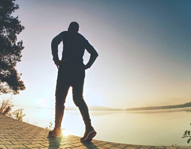 Arkadan görünüm günbatımı güneş içinde belgili tanımlık geçmiş vasıl belgili tanımlık kıyı runner adam silüeti. Vintage etkisi tarzı resimler.