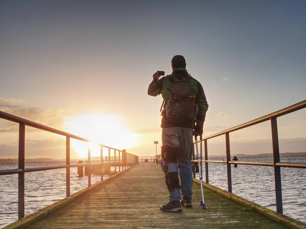 Mann Mit Handy Der Hand Fotografiert Sonnenaufgang Auf Fährhafen Maulwurf — Stockfoto