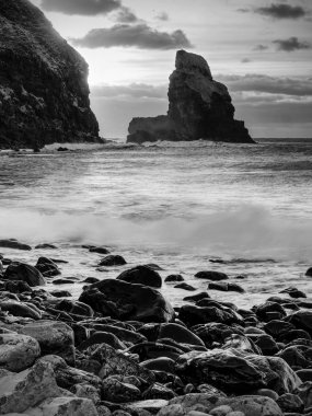 Keskin silhouettes son yapraklara pürüzsüz denizden çıkmış. Rüzgarsız denizde akşam içinde mavi atmosfer. 