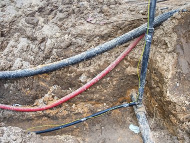 Metalik ve fiber optik kablolar ile içme suyu musluk iplik Crossection. Mekanize kazı ve bileşenlerinin yüklenmesi.