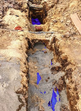 Boru ve boru hatları döşeme yol geçiş siperin içinde kablolar. Metalik ve fiber optik kablolar inşaat iletişim ağ bağlantısının satırlık bina. 