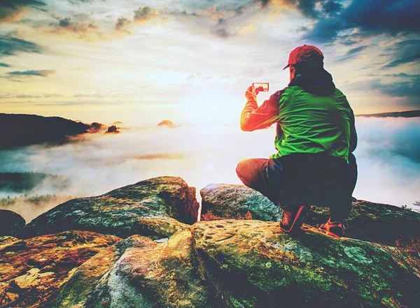 Courageous Man Sitting Peak Rock Makes Photo His Phone Autumn — Stock Photo, Image