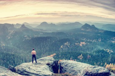 Terli gömleksiz atlet ya da beyaz kayalar karşı uzun yürüyüşe çıkan kimse onun önünde derin vadi isteyen