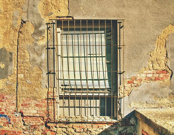 Eski paslı çubuklarıyla kaplı tuğla-up windows ile gecekondu evde Duvar tuğla.