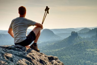 Uzun yürüyüşe çıkan kimse trekking giysili rock Zirvesi rahat otur. Dağlarda harika daybreak