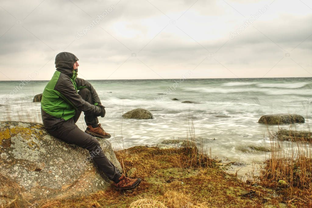 Man looks over sea bay and enjoy wild nature. A man admires the beauty of nature force