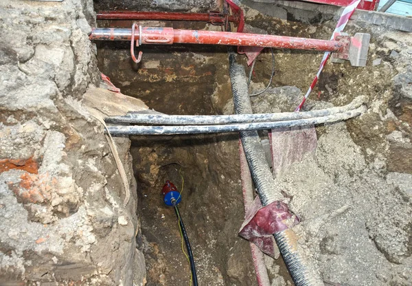 Building of lines of metallic and fiber optic cables of communication network connection.  The trench carries the conduits for gas water electric sewage and phone services