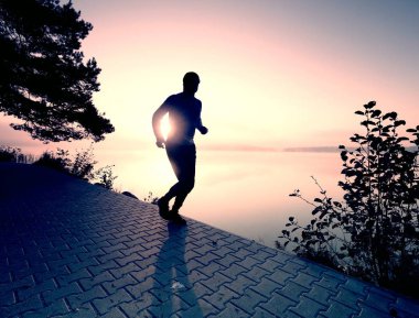 Gün batımı arka plan kopya alanı üzerinde atlet silüeti. Sportif şekil uygulamaları spor yaşam için çalışan adam. Spor ve eğitim kavramı.