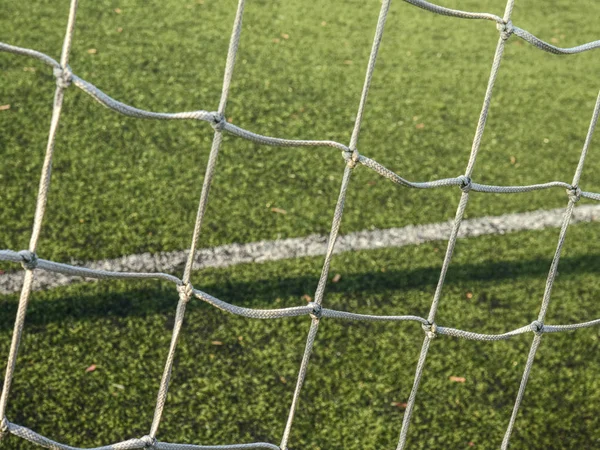 在足球网中 挂着白色的足球网 背景在足球场上的草和白色画的线 — 图库照片