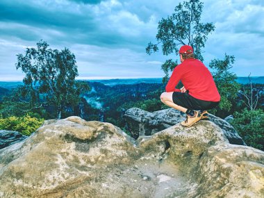Runner pembe ceket ve ışık siyah şort. Kısa kızıl saçlı adam rocky Dağları'nda yolda.