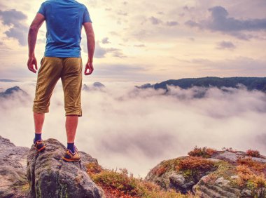 Uzun yürüyüşe çıkan kimse ortada hiçbir yerde ve yalnız düşünme. Adam gündoğumu zevk keskin bir tepe üzerine oturmak.