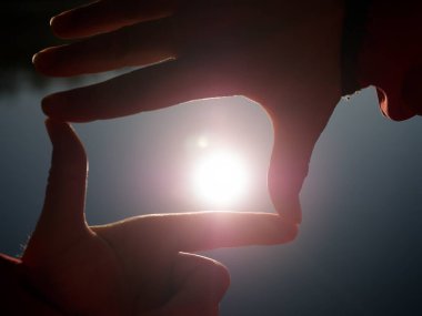 El tarih Pzr. Güneş tutan el silüeti. Güneş su seviyesinden düşük. Güzel gölge oyunu.