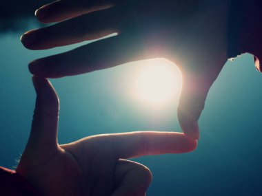 Parmak şekli jest, kumsalda güneş patlaması tutan el yapım eller.