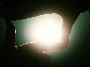 Güneşin göl düzeyde doğru el uzatmak. Günbatımı katlanmış parmaklarımın arasından bakmak