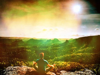 Adam uzun yürüyüşe çıkan kimse dağda bir kayanın üzerine oturmuş. Soyut, üzerinde filtre. Adam sit. Sonbahar dağ sis. Vadilerde sis