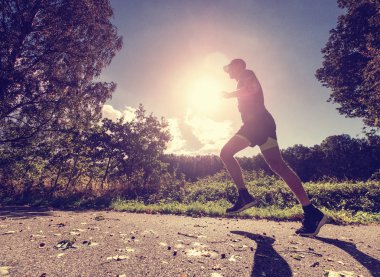 Ormanda koşan adam. Bir orman iz üzerinde koşan atletik adam. Warmday üzerinde koşan adam