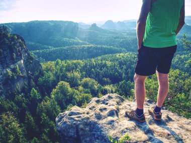 Yeşil singlet ve siyah pantolon korkusuz çocuk kayalarda. Vahşi doğa manzara şaşırtıcı görünüme.