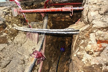Metalik ve fiber optik kablolar ile içme suyu musluk iplik Crossection. Mekanize kazı ve bileşenlerinin yüklenmesi.