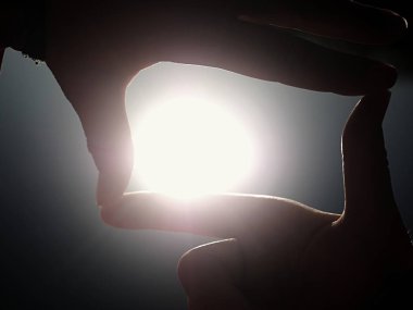 Parmak şekli jest, kumsalda güneş patlaması tutan el yapım eller.