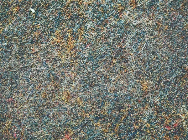 Old worn carpet sewn with thick threads in detail. Used industrial carpet with some defects.