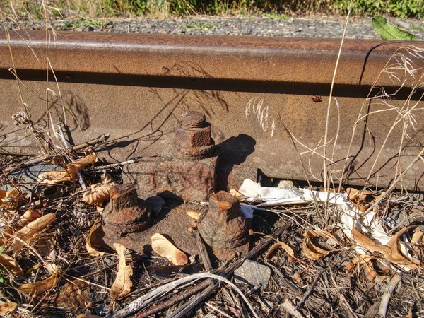 Rusty abandoned rails. Terrible smell rotten old wooden ties with phenol asphalt paint. Environmental burden environmental hazards.