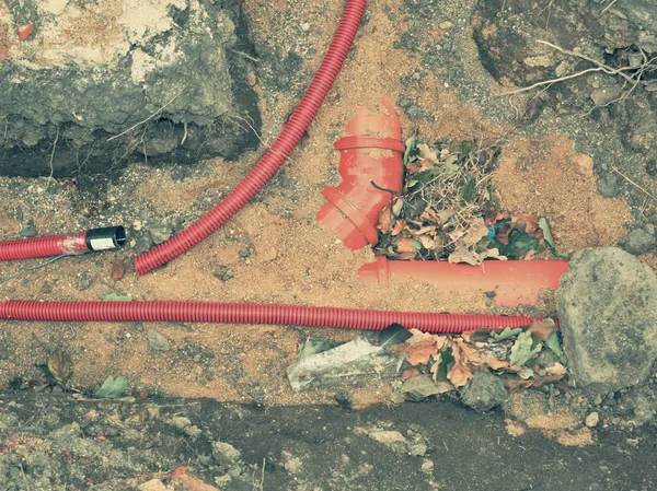 Wire in HDPE and red protectivep pipe. Lines of metallic and fiber optic cables construction of communication optical network connection