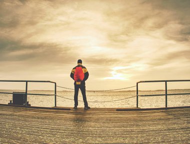 Adam tarafından köprü Nehri yakınında Sonbahar sezonunda yürüyüş sırt çantası ile.