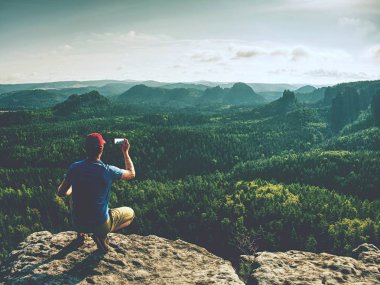 Smartphone kullanarak dağ manzara panoramik resim çekmek adam hiking.