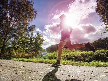 Bir orman iz üzerinde koşan atletik adam. Sonbahar ormandaki bir iz üzerinde koşan adam