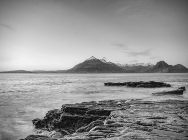Taş ve kayalar kıyısında. Zavallı günbatımı hafif, yumuşak su sıcak. Skye İskoçya