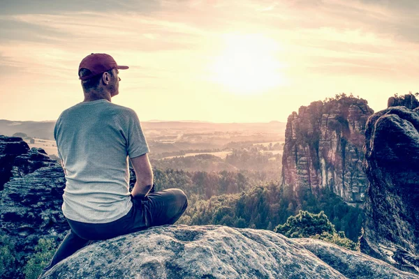 Vadi Üzerinde Günbatımında Bakarken Rock Tepenin Üstüne Oturan Adam Hiker — Stok fotoğraf
