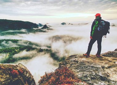 Adam sisli kayalarda yürürken an için durdu. Güneş ufuktan soğuk bulutlar içinde gizli kalın sis vadiye üzerinde göster.