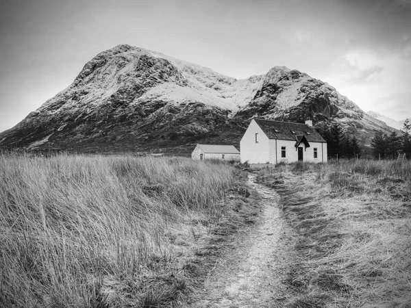 Climbers base, white house at Glencoe mountain, Scottish Highlands, Scotland. Sunny spring day, February 2017.