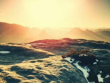 Güçlü bahar güneş ışınları uzun tut manzarada gölgeler. Kar geri kalanı. Kayalık parkta hiking puslu Vadisi üzerinden güneşli görünüm.