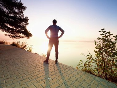 Orta runner dur nefes için yaşlı. Sporcu bir mola alır ve sabah güneş ufuk üzerinde seyir
