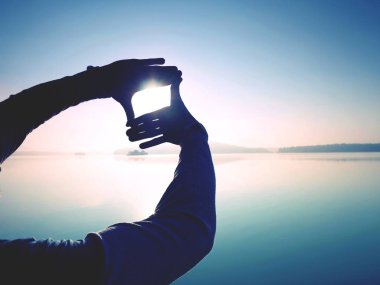 Siluet gölge şeklin plajda güneş ışığı ile el tarafından yapılıyor. Deniz günbatımı.