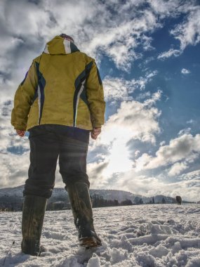 Güneş düşük görüş açısı karşı karda jest kadın sarı siyah iş elbiseleri ve lastik çizmeler.