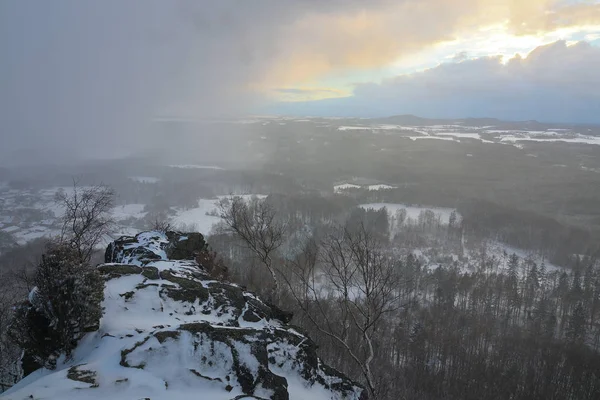 雪のストーニーの丘 冬の雪 玄武岩の石の山の上 霧の森と 憂鬱な気分 — ストック写真