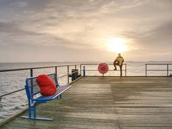 Einsamer Mann Auf Pier Und Blick Über Geländer Ins Wasser — Stockfoto