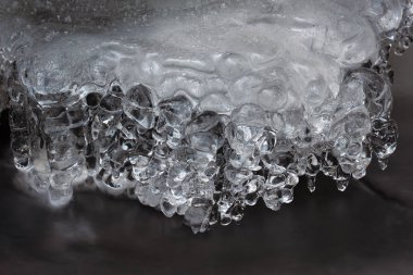 Ayrıntı Nehri'nde buz. Buz sarkıtları parlak yansımalar beyaz köpük su seviyesi üzerinde bulanıklık. Buzlu sanat