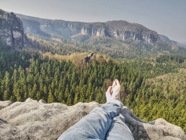 Tired hikers legs without shoes. Traveler relaxing with mountains view on background
