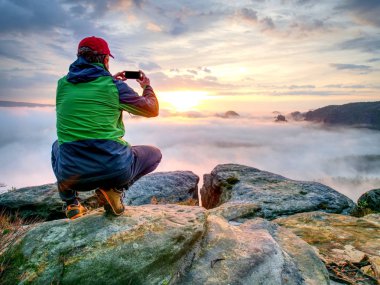 Erkek Gezgin Görünümü arkadaş scial ağ üzerinden için dağlar manzara sonbahar paylaşımı Mobil cep telefonu kullanarak. 