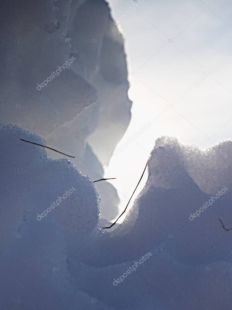 Piece of ice with strong contour and sun flares. Ice crystals on a ice plate 