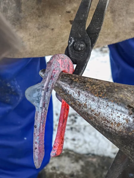 Smeden arbetar för att slutföra hästsko — Stockfoto