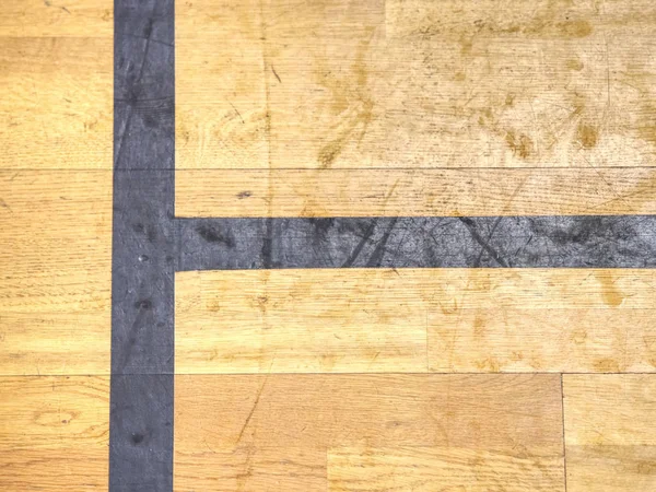 Black line. Worn out wooden floor of sports hall with marking lines