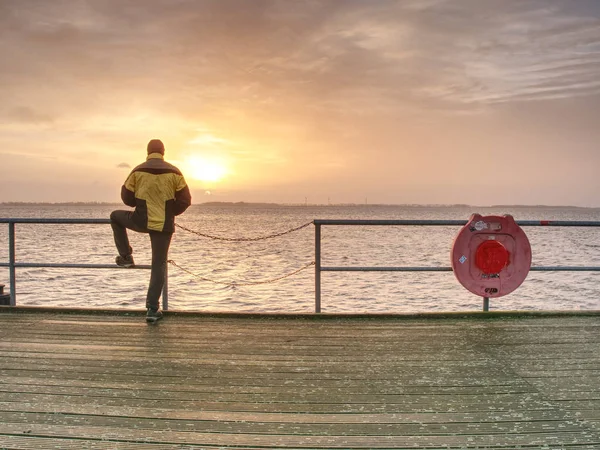 Mann steht auf Maulwurf und blickt aufs Meer — Stockfoto