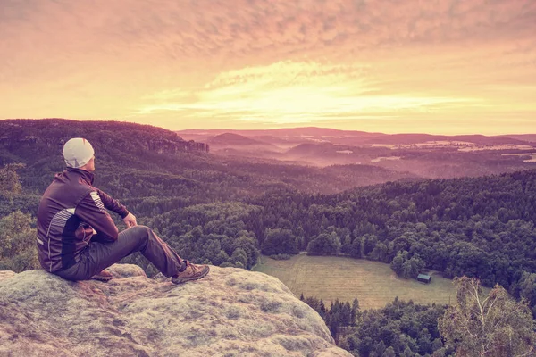 Rear view of man hiker sitting on rock on top — Stock Photo, Image